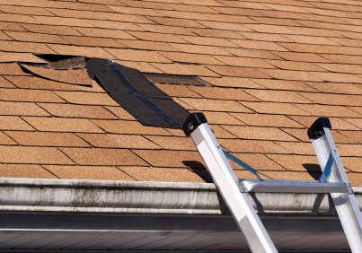 Fixing damaged roof shingles. A section was blown off after a storm with high winds causing a potential leak.